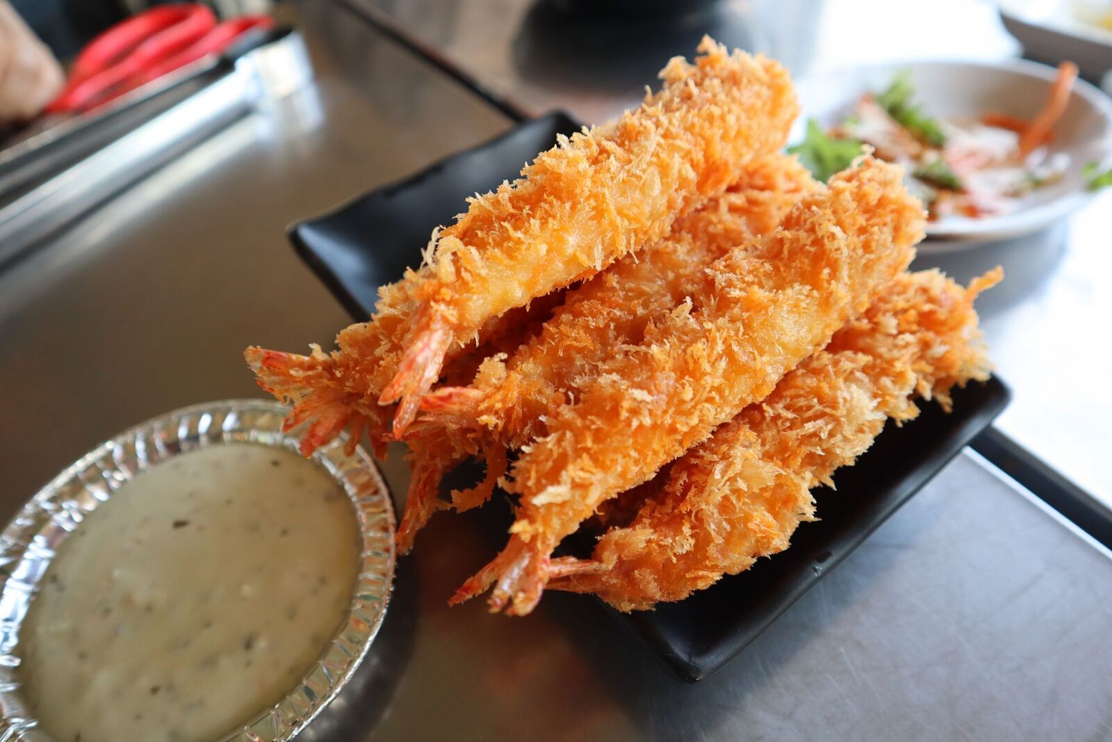 Gamberi fritti con salsa su un piatto nero