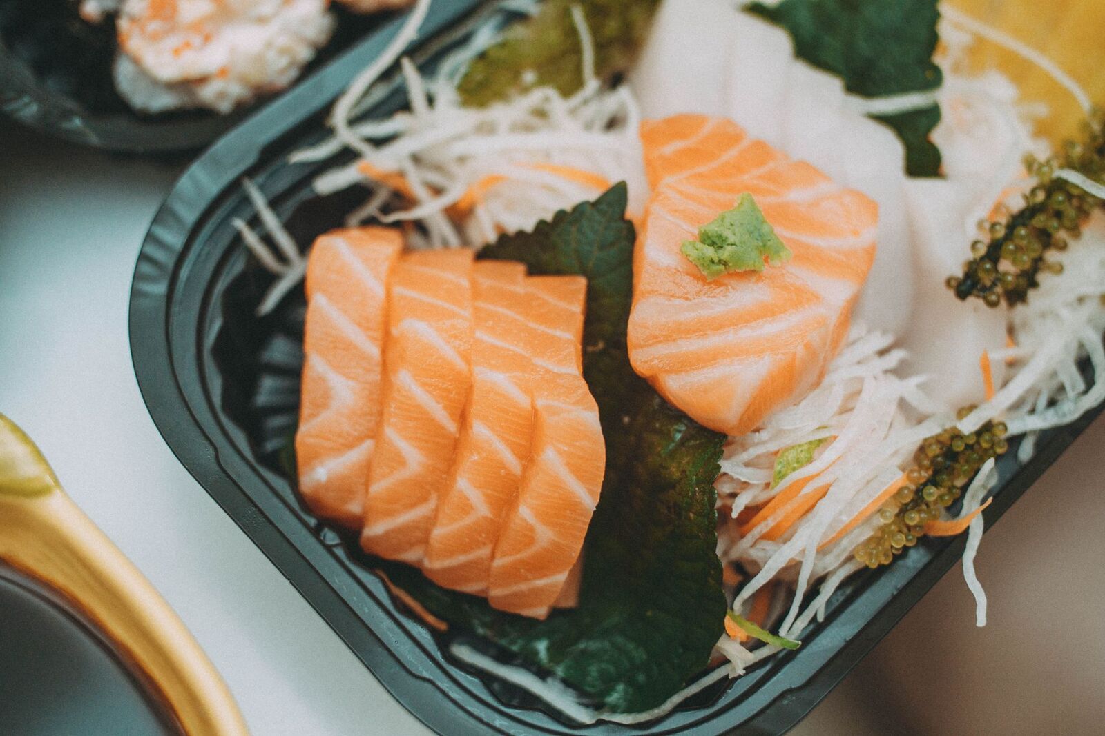 Sashimi di salmone su un piatto nero